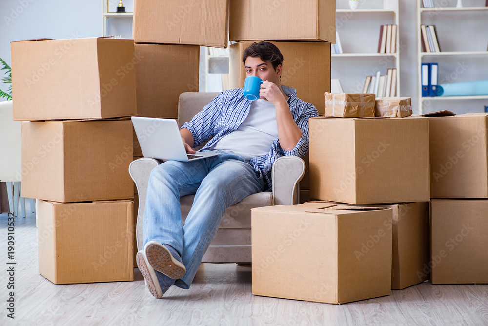 Young man moving in to new house with boxes Young man moving in to new house with boxes