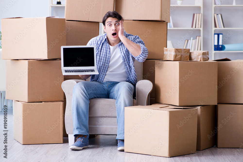 Young man moving in to new house with boxes Young man moving in to new house with boxes