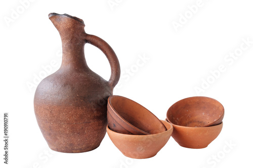 Terracotta clay jug and a few wine cups on a white background, isolated © Luka