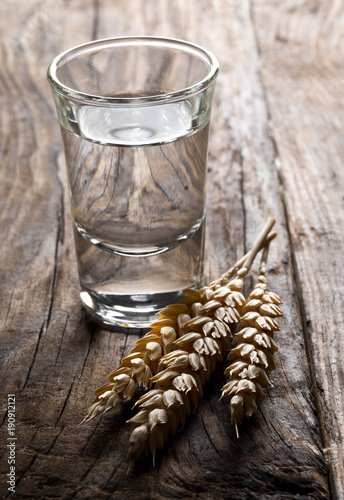 Φωτογραφία German hard liquor Korn Schnapps in shot glass with wheat ears