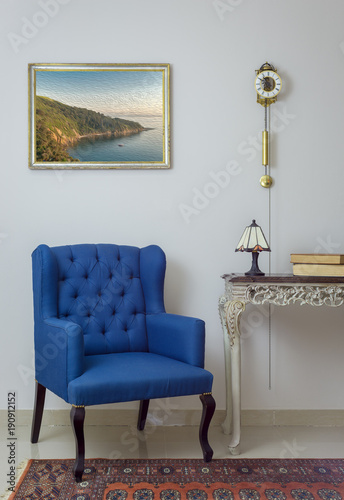 Vintage Furniture - Interior composition of retro blue armchair  vintage wooden beige table  table lamp  books  and pendulum clock over off white wall  tiled beige floor and orange ornate carpet