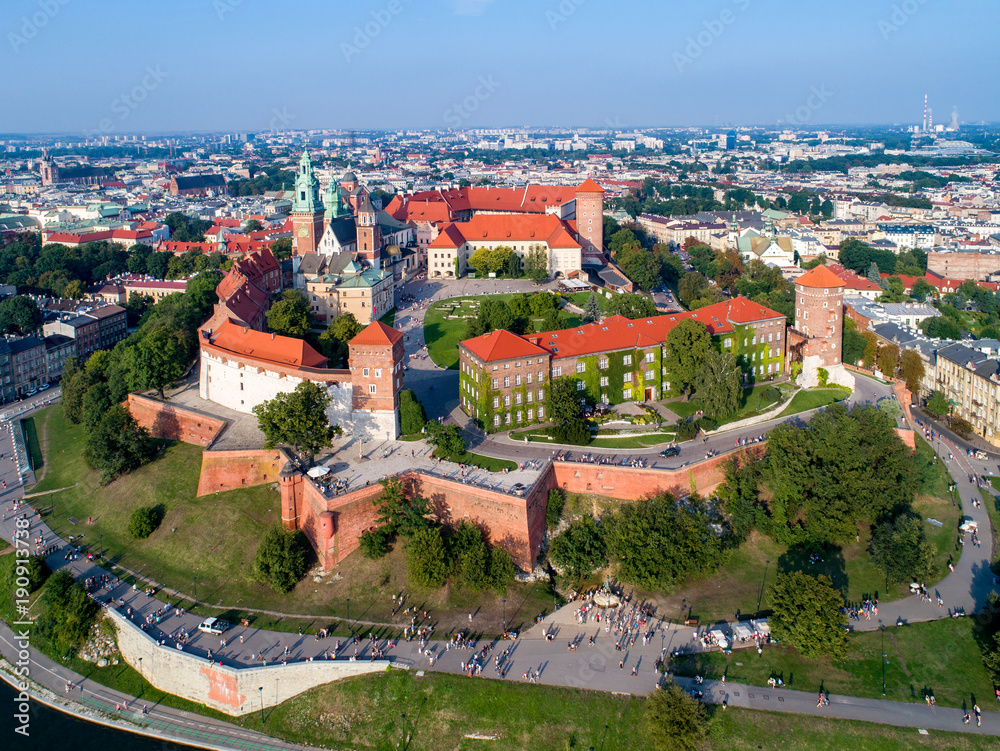 Poland. Skyline panorama of Krakow old city with Wawel Hill,  Cathedral, Royal Wawel Castle, fortified walls, park, promenade and unrecognizable walking people.