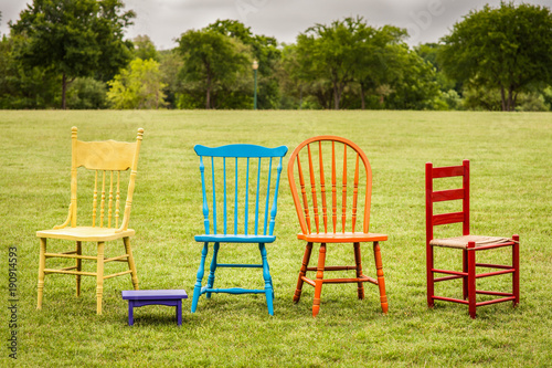 colored chairs in an open field at spring time 
