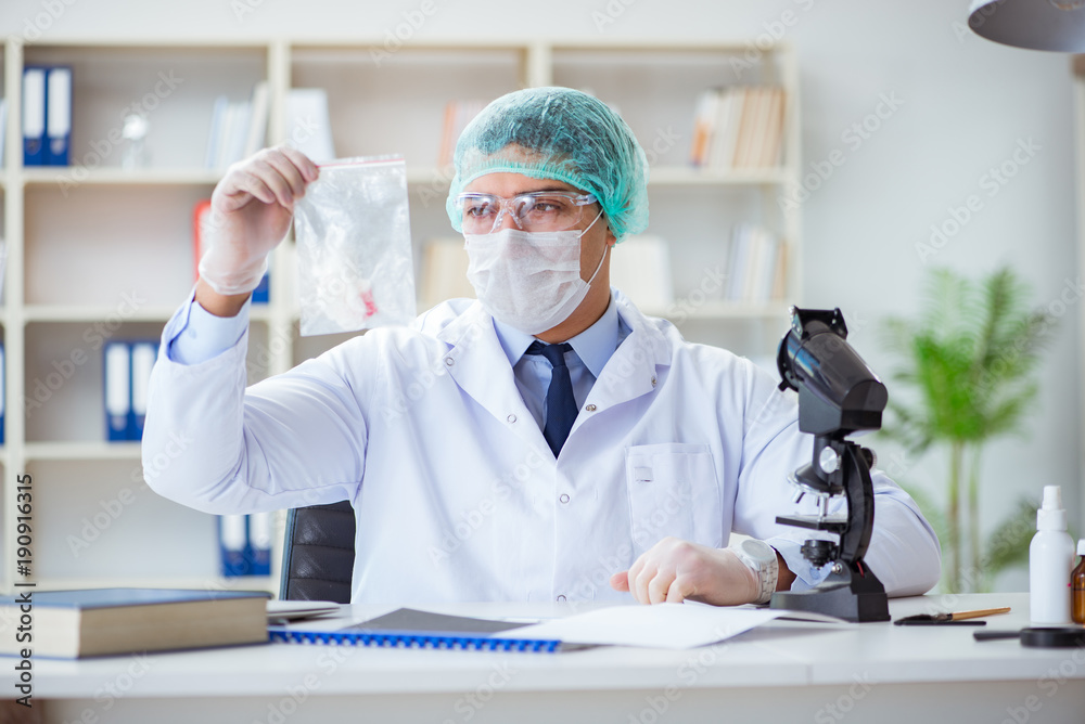 Forensics investigator working in lab on crime evidence Forensics investigator working in lab on crime evidence