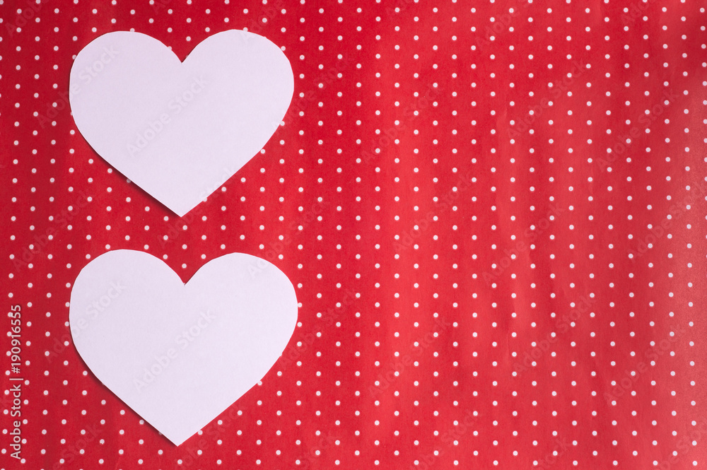 white hearts carved from paper on a red background. Valentine's Day greeting card