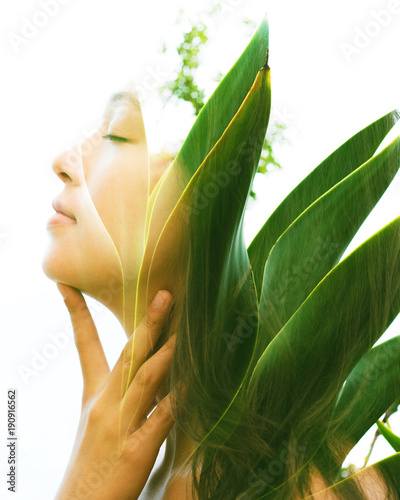 Double exposure of a young natural beauty with closed eyes, relaxing and softly touching her throat and chin as her face and hair combine perfectly with bright tropical leaves