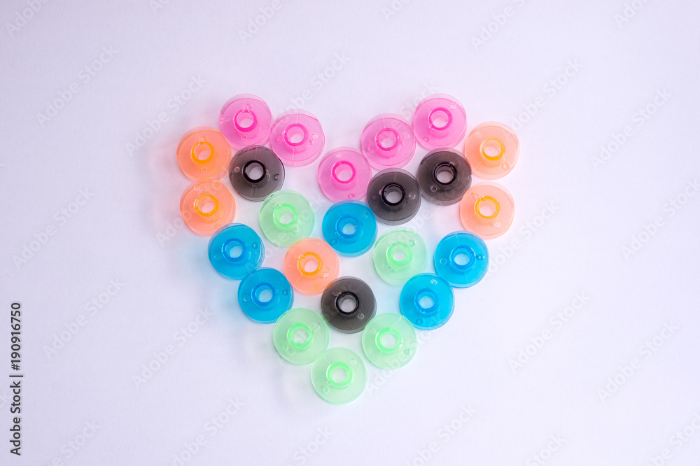 hearts from sewing colorful bobbins on white phonetics. Valentine's Day greeting card, hearts from sewing colorful bobbins on white phonetics. Valentine's Day greeting card,