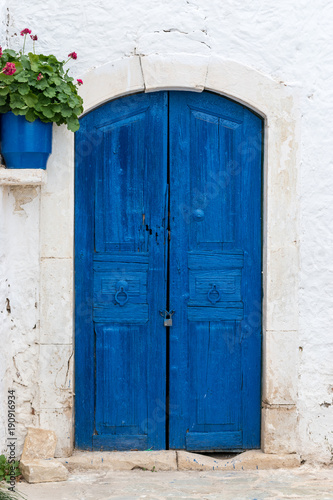 Old wooden door on white stone wall.