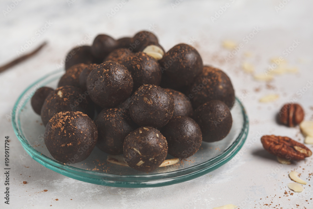 Vanilla-chocolate raw vegan sweet balls with nuts, dates and cocoa. Healthy vegan food concept. Gray background Vanilla-chocolate raw vegan sweet balls with nuts, dates and cocoa. Healthy vegan food concept. Gray background