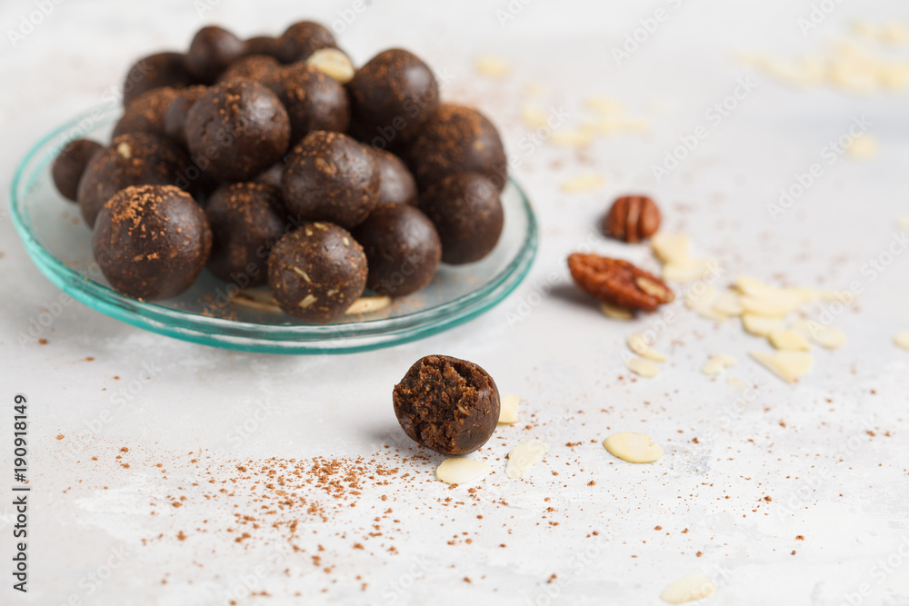 Vanilla-chocolate raw vegan sweet balls with nuts, dates and cocoa. Healthy vegan food concept. Gray background Vanilla-chocolate raw vegan sweet balls with nuts, dates and cocoa. Healthy vegan food concept. Gray background