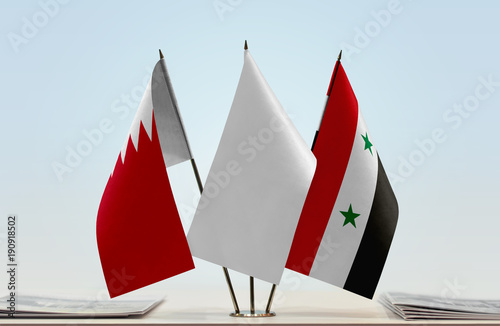 Flags of Bahrain and Syria with a white flag in the middle photo