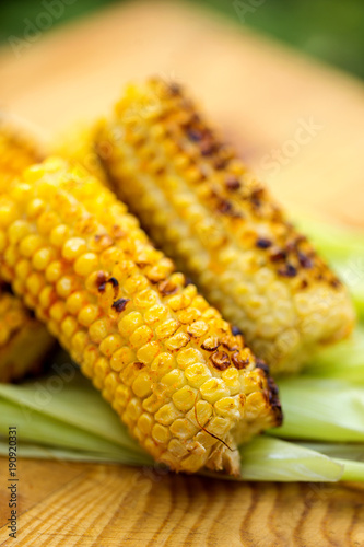 Grilled corn cobs on rustic wood
