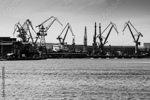 Gdansk shipyard, Poland. Retro style black and white. Cranes, old shipyard buildings, rusty structures.