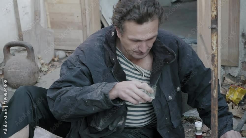 A homeless alcoholic drinks vodka at the dump (full HD) A homeless alcoholic drinks vodka at the dump (full HD)