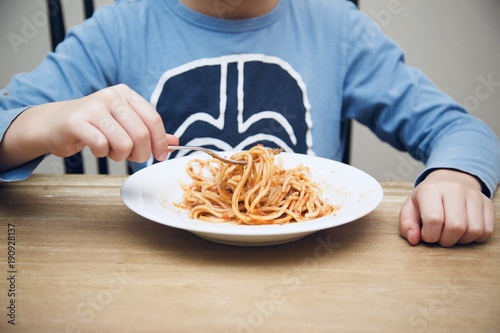 child eats spaghetti