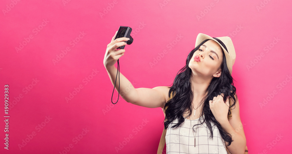 Traveling young woman holding a camera on a solid background Traveling young woman holding a camera on a solid background