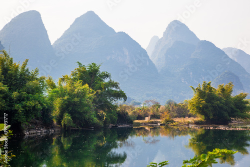 Beautiful landscape of karst mountains reflected in water, Yulong river in Yangshuo South China.