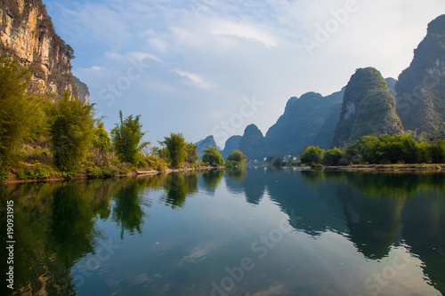 Beautiful landscape of karst mountains reflected in water, Yulong river in Yangshuo South China.