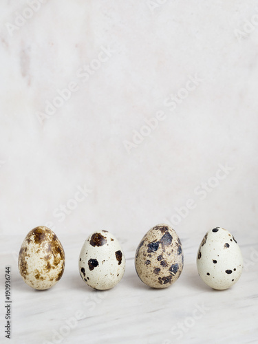 Four quail eggs on a marble background
