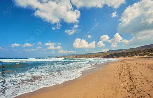 Beautiful wild beach with clear turquoise water and waves.