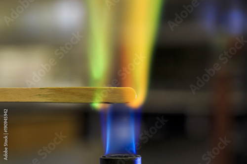 Copper solution burning on a wooden splint in a bunsen burner flame. photo