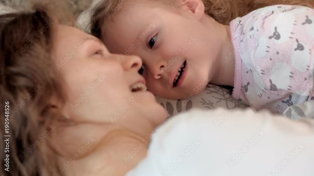 Happy woman and girls playing lying on the floor at home Happy woman and girls playing lying on the floor at home