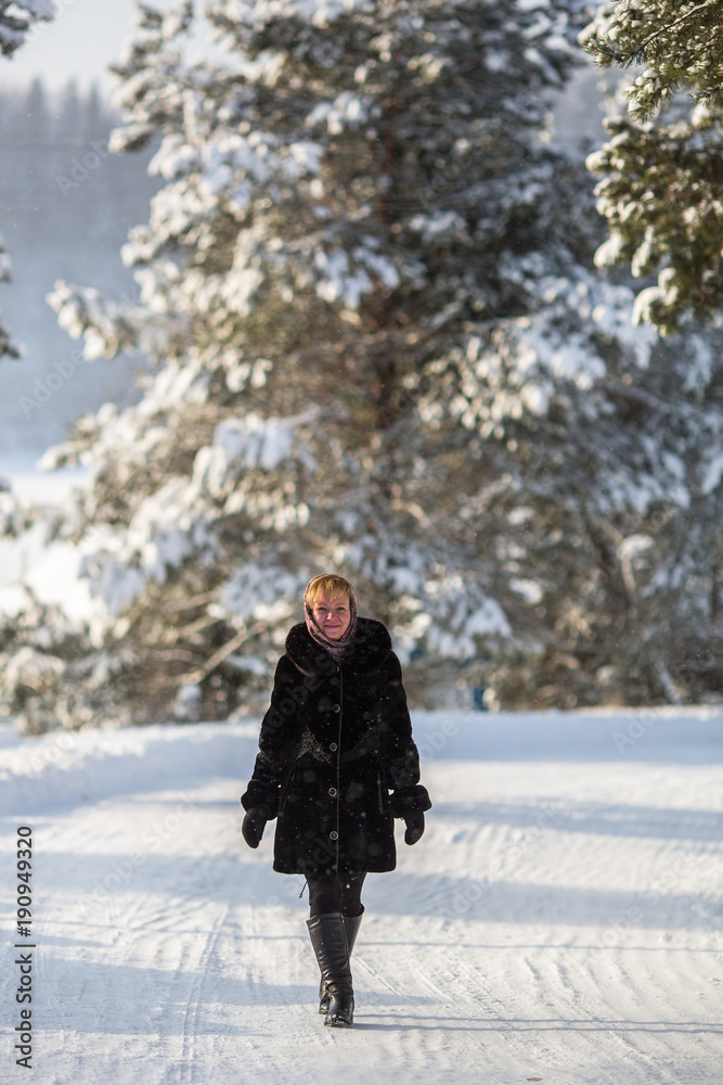 Young woman standing in the winter on a snowy road.