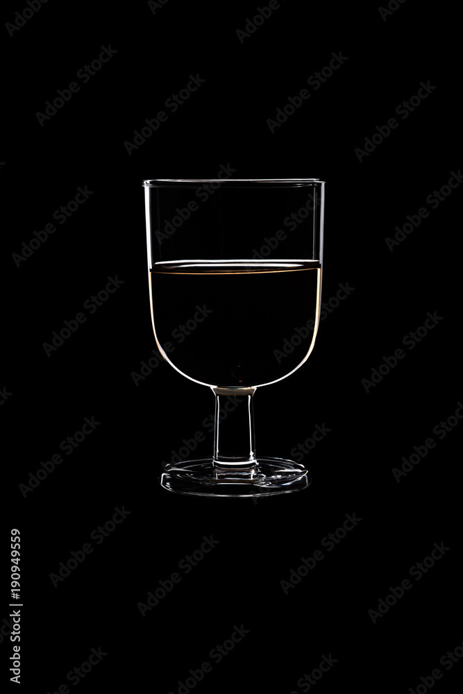 A low glass with white wine. A low glass with white wine.
