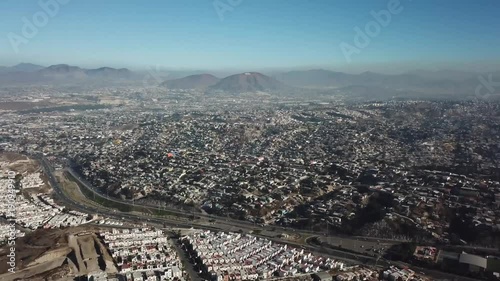erial footage of a residential area in Tijuana, Baja California, Mexico during a Santana, local name for sand storm. High density of houses in a desert area, dusty sky.