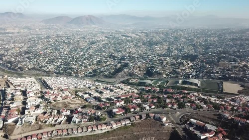 erial footage of a residential area in Tijuana, Baja California, Mexico during a Santana, local name for sand storm. High density of houses in a desert area, dusty sky.