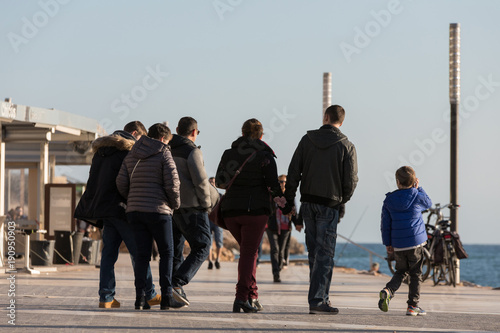 People walking on the seashore in a beach town leading a daily life