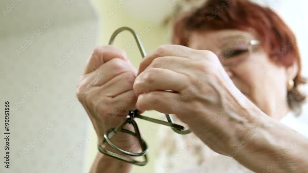 An old woman unravels a metal puzzle, coaches brain activity An old woman unravels a metal puzzle, coaches brain activity