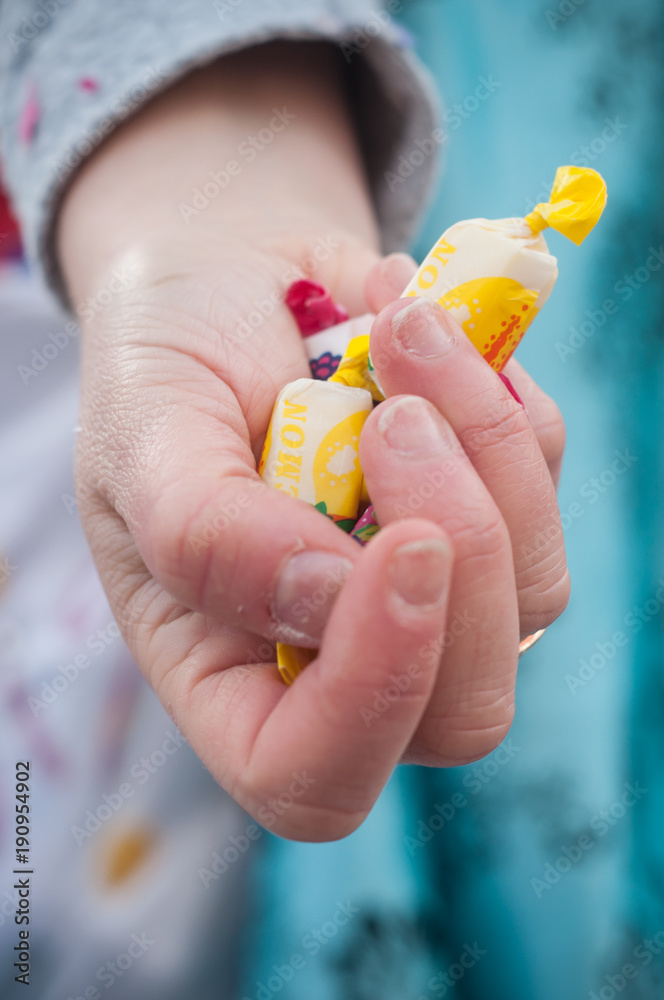 détail main d'enfant tenant des bonbons dans la main