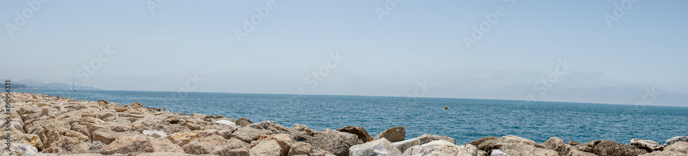 Panoramic view of the ocean at Malagueta beach with rocks at Malaga, Spain, Europe
