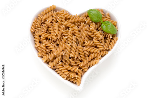 Uncooked wholemeal pasta isolated white background.