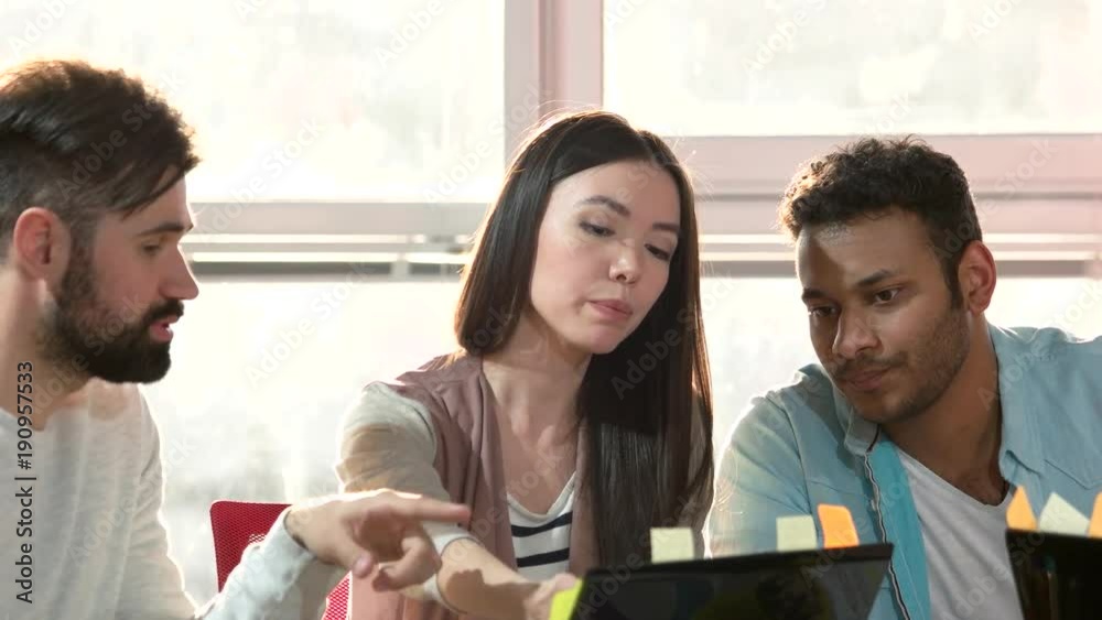 Close up multiethnic people discussing. Young office interns working on laptop computer in office.