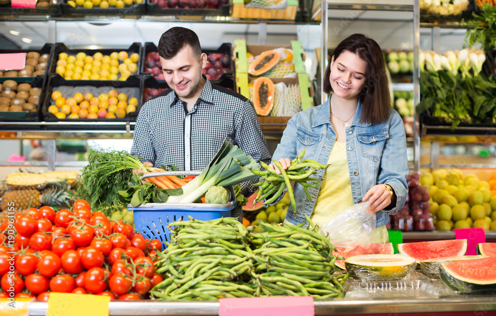 Cheerful couple examining various vegetables