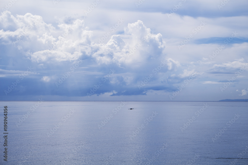 Sea and sky double landscape. Seashore view with fishing boat.