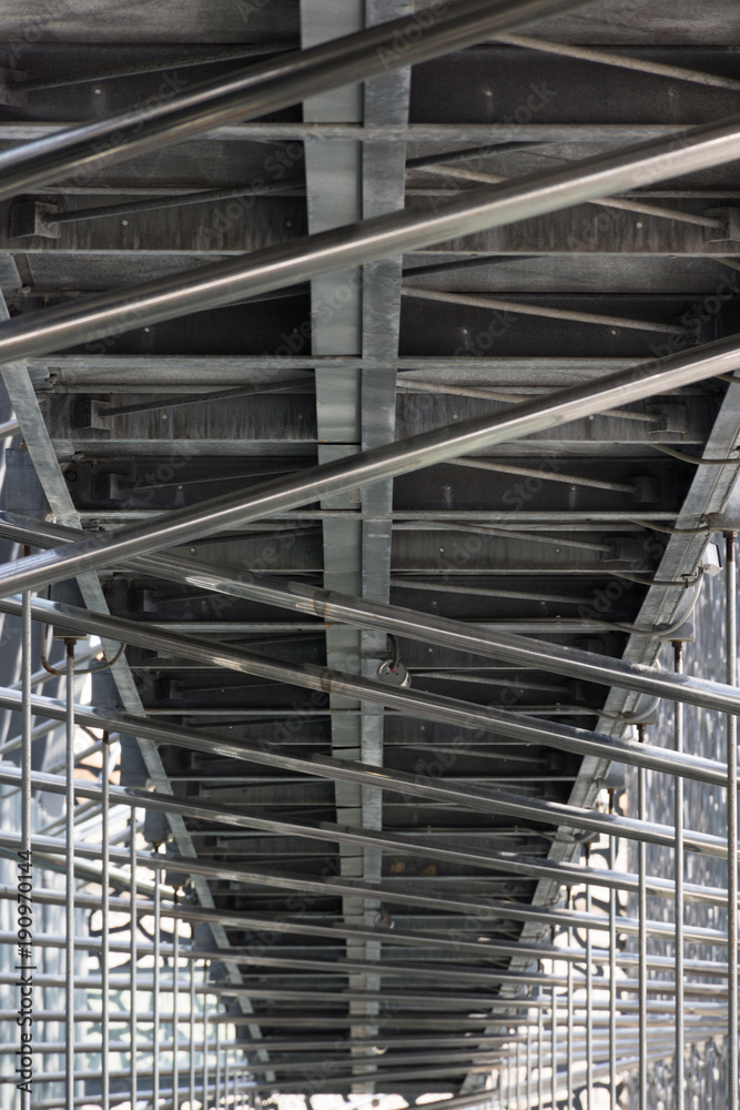 Architectural Detail of Mucem with metal pipe scaffolding and a metal walkway photographed from below.