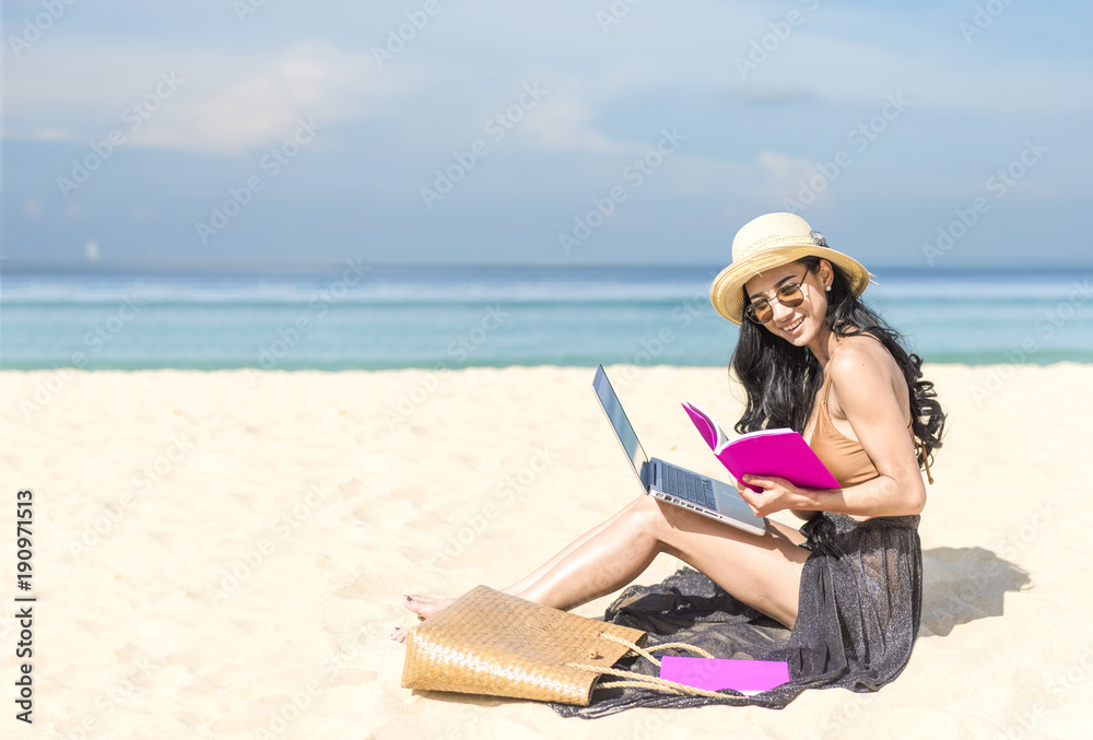 woman using laptop computer on a beach. Freelance work concep