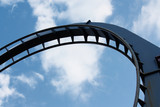 Blue steel rollercoaster loop against a bright blue summer sky