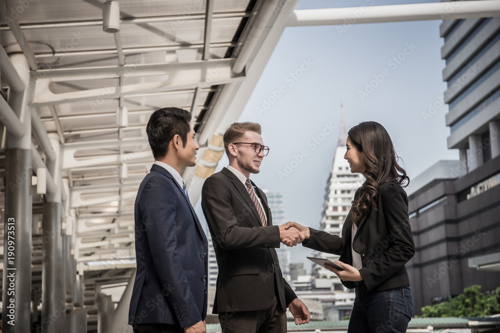 Business partner shaking hands and smiling while meeting in front of office. Business and success concept. Business partner shaking hands and smiling while meeting in front of office. Business and success concept.