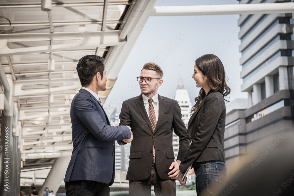 Business partner shaking hands and smiling while meeting in front of office. Business and success concept. Business partner shaking hands and smiling while meeting in front of office. Business and success concept.