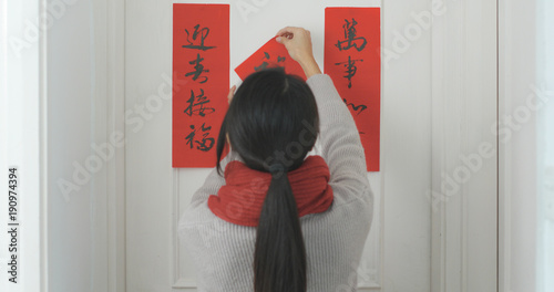 Woman sticking chinese calligraphy on the door photo