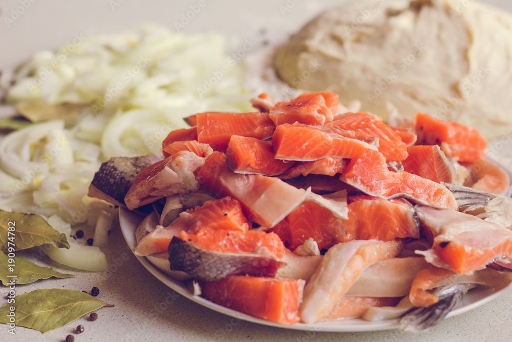Ingredients for cooking fish cake. Fish salmon, trout, dough, onion, seasoning. The fish is crushed and lies on a plate. Ingredients for cooking fish cake. Fish salmon, trout, dough, onion, seasoning. The fish is crushed and lies on a plate.