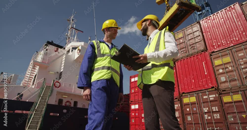 Dock workers discuss logistics at the harbor amidst shipping industry activity. Shot on RED Epic.