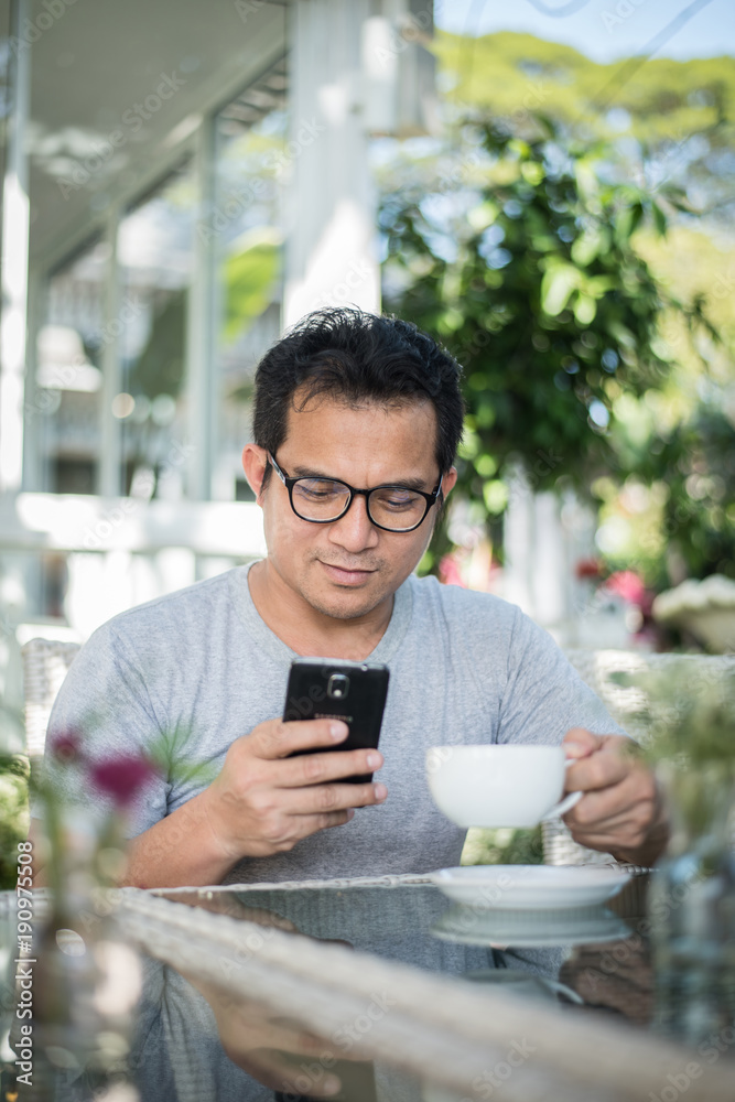 Handsome man using mobile phone at the cafe Handsome man using mobile phone at the cafe