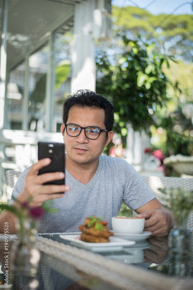 Handsome man using mobile phone at the cafe Handsome man using mobile phone at the cafe