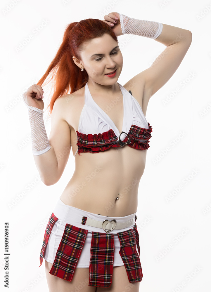 young sexy striptease dancer in a miniskirt on a light background young sexy striptease dancer in a miniskirt on a light background