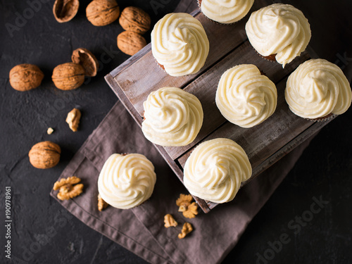 Carrot cupcakes or muffins with nuts on dark background